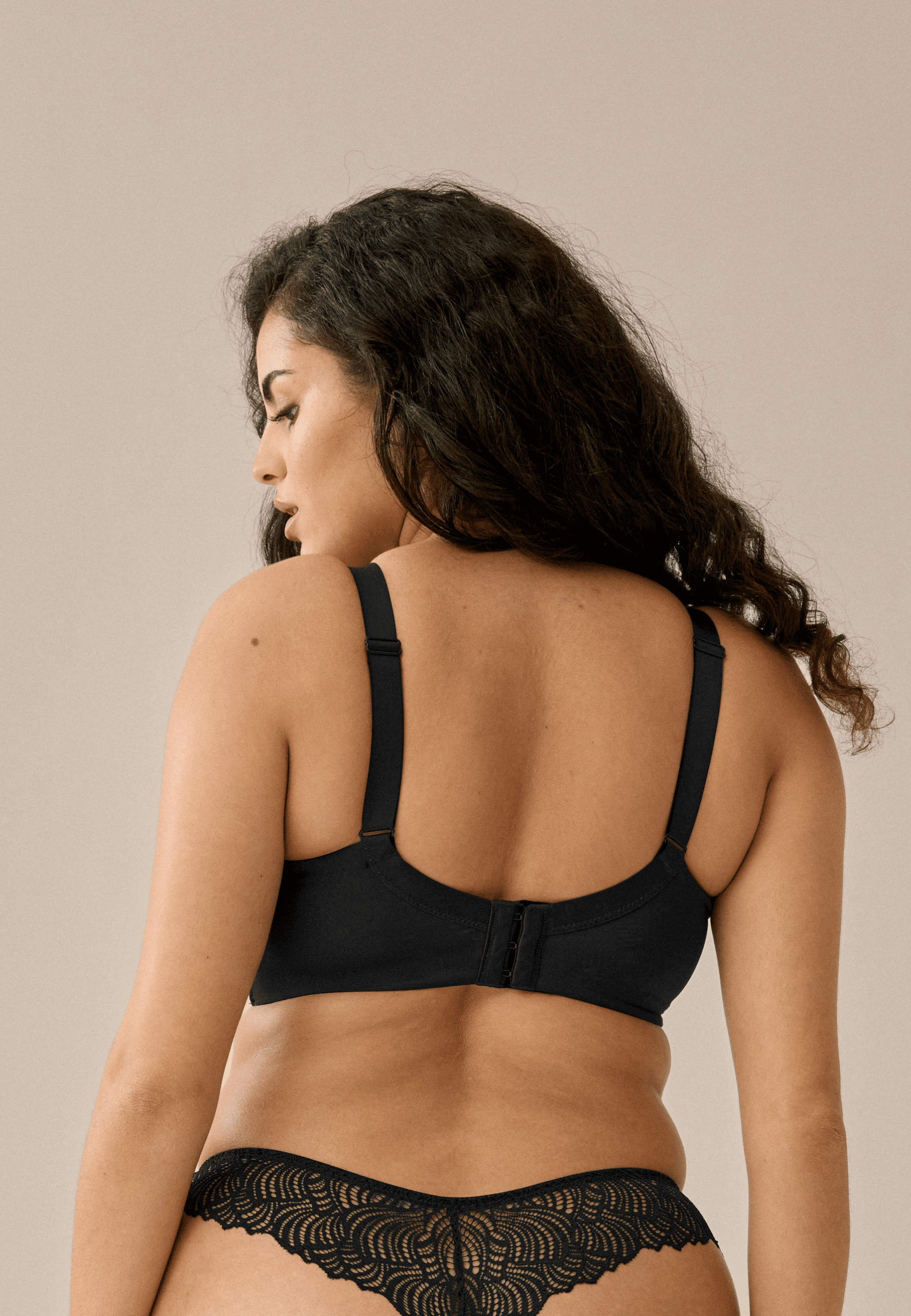Achterzijde van vrouw die de soft bh met gerecycled kant in de kleur zwart van het merk Naturana draagt