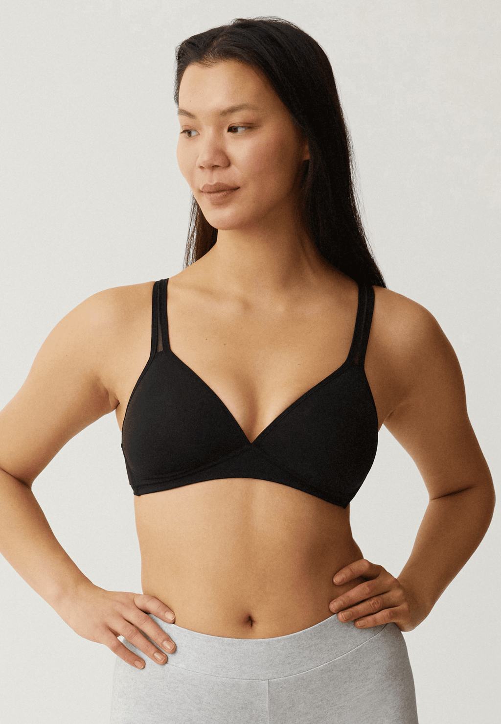 Voorzijde van vrouw die de soft bh met mesh bandjes in de kleur zwart van het merk Naturana draagt