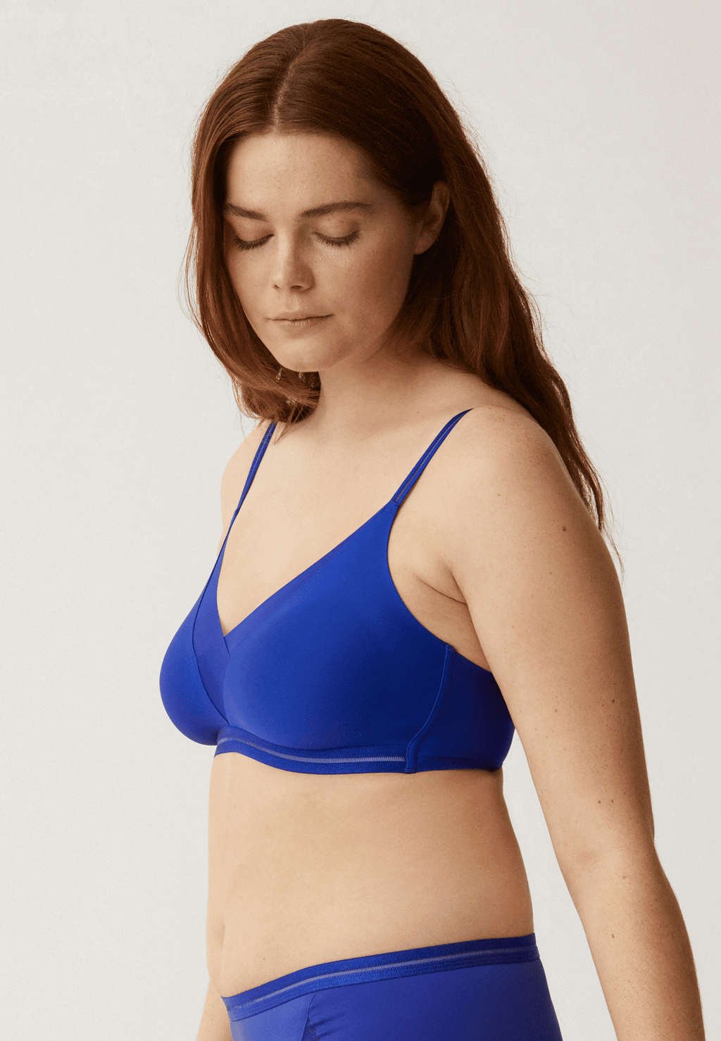 Zijde van vrouw die de soft bh met mesh detail in de kleur indigo van het merk Naturana draagt