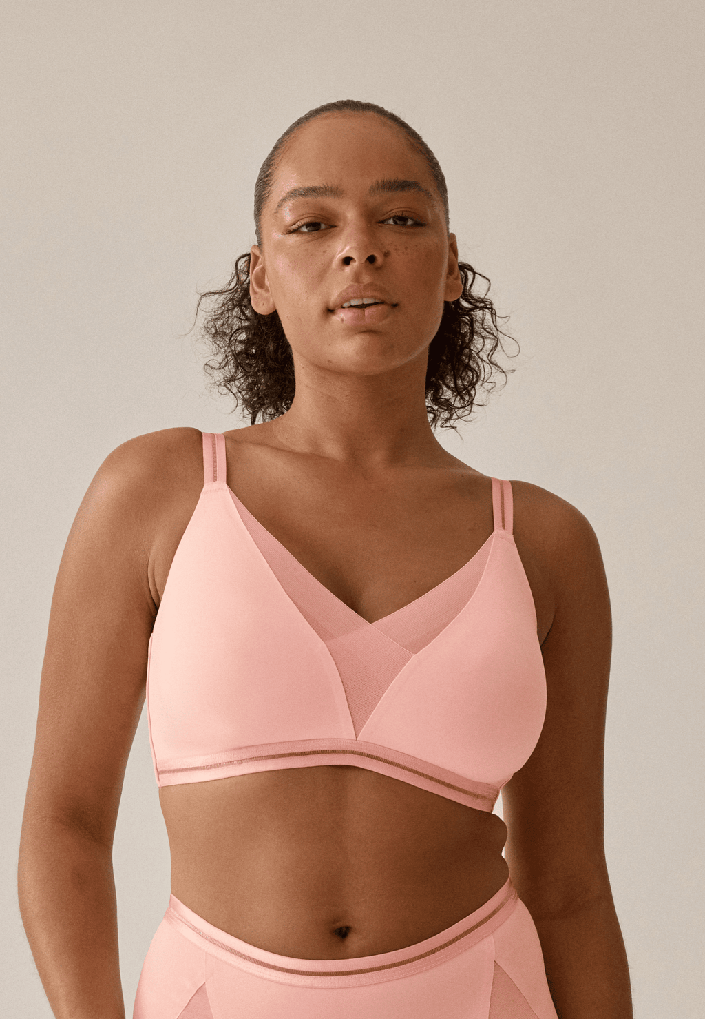 Voorzijde van vrouw die de soft bh met mesh detail in de kleur pink rose van het merk Naturana draagt