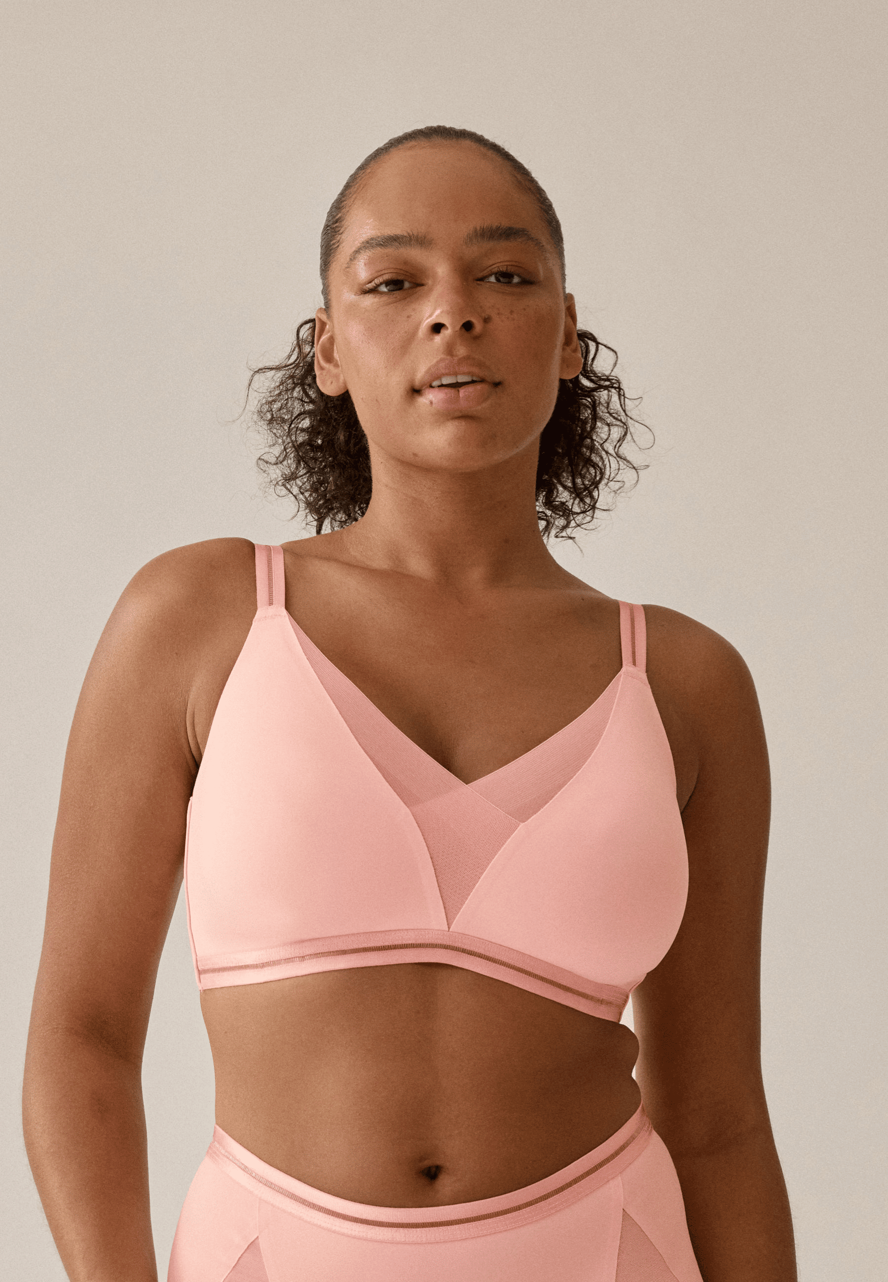 Voorzijde van vrouw die de soft bh met mesh detail in de kleur pink rose van het merk Naturana draagt