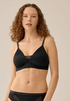 Voorzijde van vrouw die de voorgevormde soft bh met mesh detail in de kleur zwart van het merk Naturana draagt