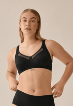 Voorzijde van vrouw die de soft bh met meshrand in de kleur zwart van het merk Naturana draagt