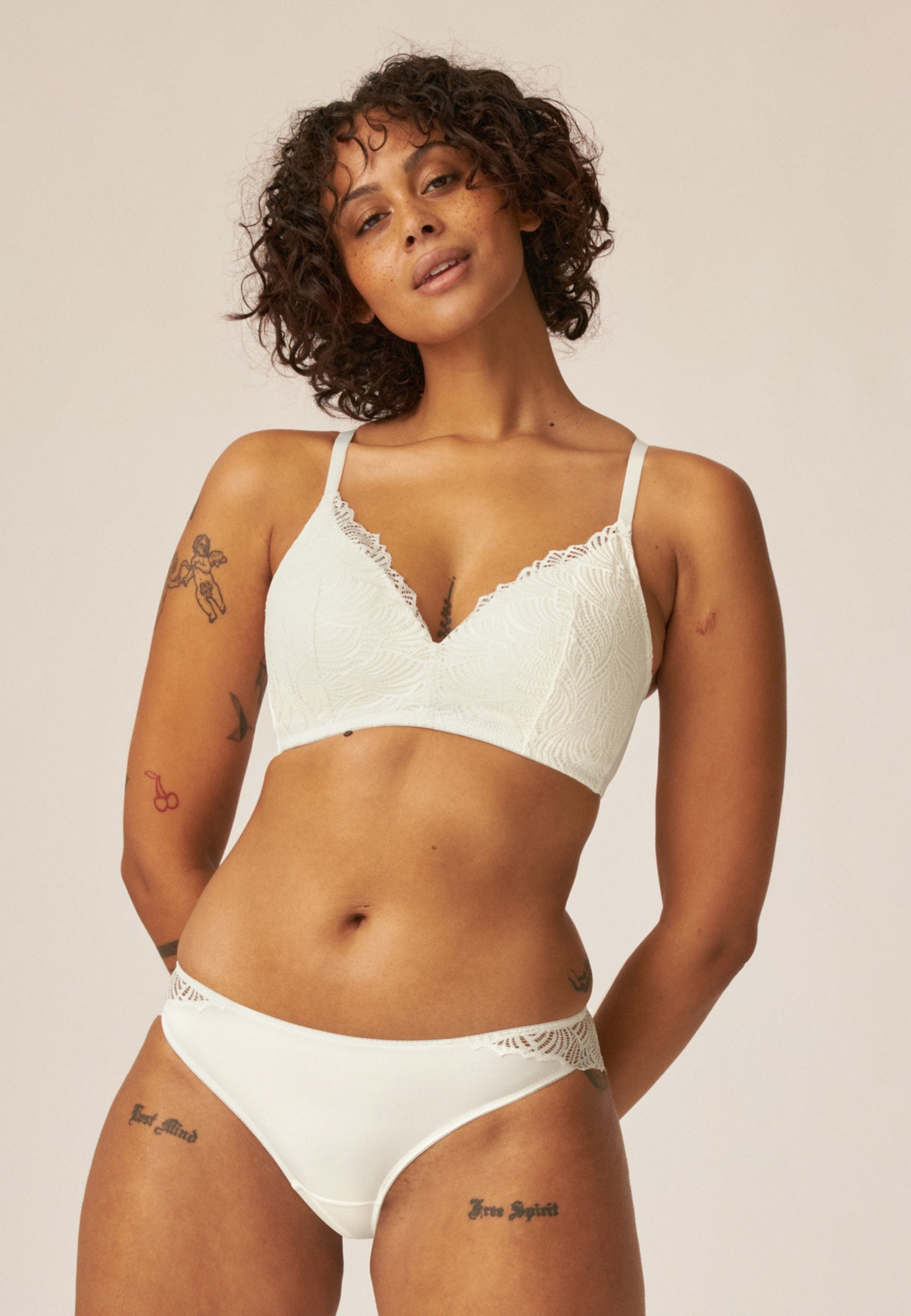 Voorzijde van vrouw die de de soft bh  met gerecycled kant en slip met gerecycled kant in de kleur ecru van het merk Naturana draagt