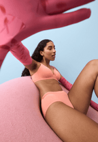 Zijde van vrouw die de soft bh met glansband en slip met glansband in de kleur peach pink van het merk Naturana draagt