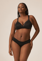 Voorzijde van vrouw die de soft bh met glansband en slip met glansband in de kleur zwart van het merk Naturana draagt