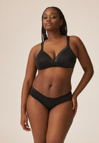 Voorzijde van vrouw die de soft bh en slip met glansband in de kleur zwart van het merk Naturana draagt