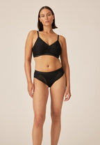 Voorzijde van vrouw die de soft bh en slip met mesh detail in de kleur zwart van het merk Naturana draagt