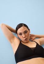 Voorzijde van vrouw die de voorgevormde soft bh met mesh detail in de kleur zwart van het merk Naturana draagt