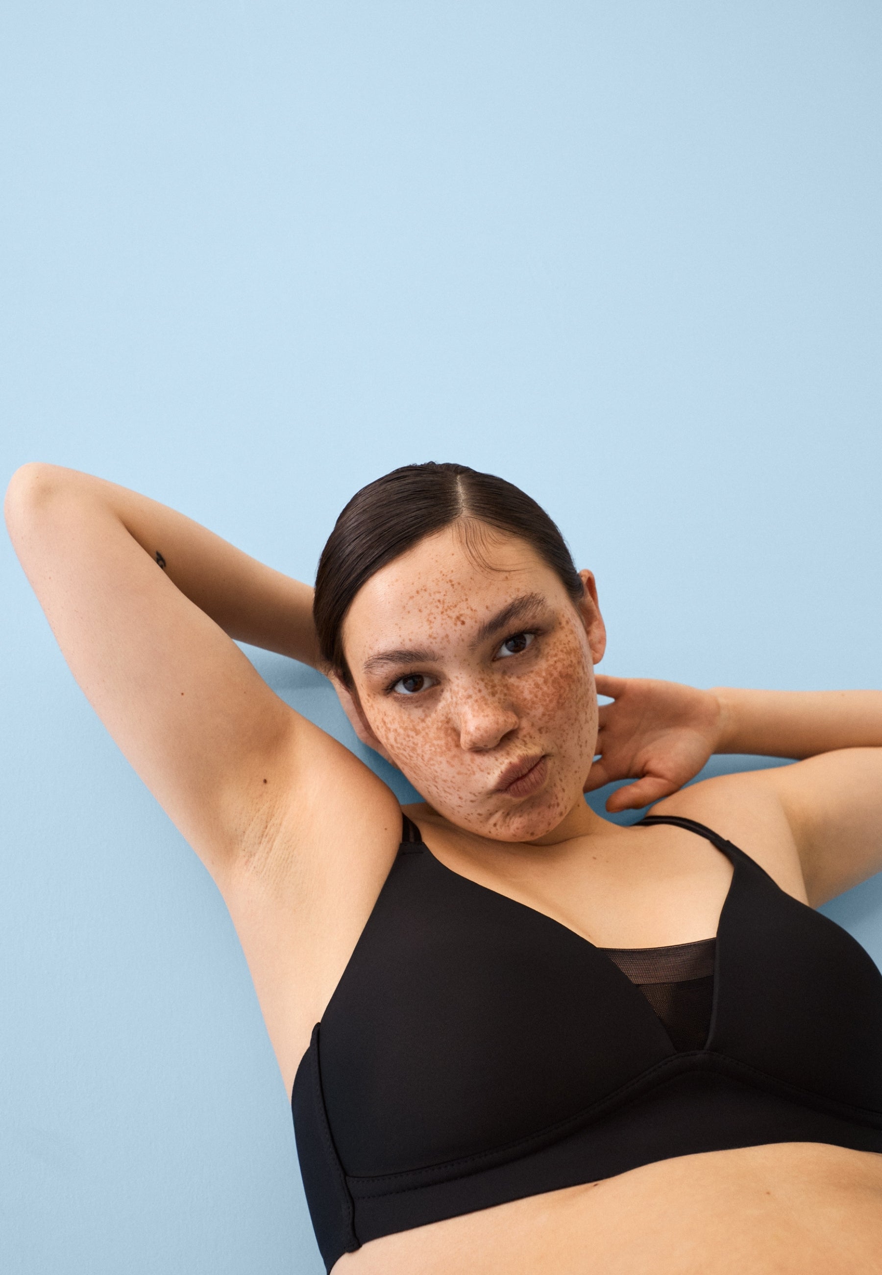 Voorzijde van vrouw die de voorgevormde soft bh met mesh detail in de kleur zwart van het merk Naturana draagt