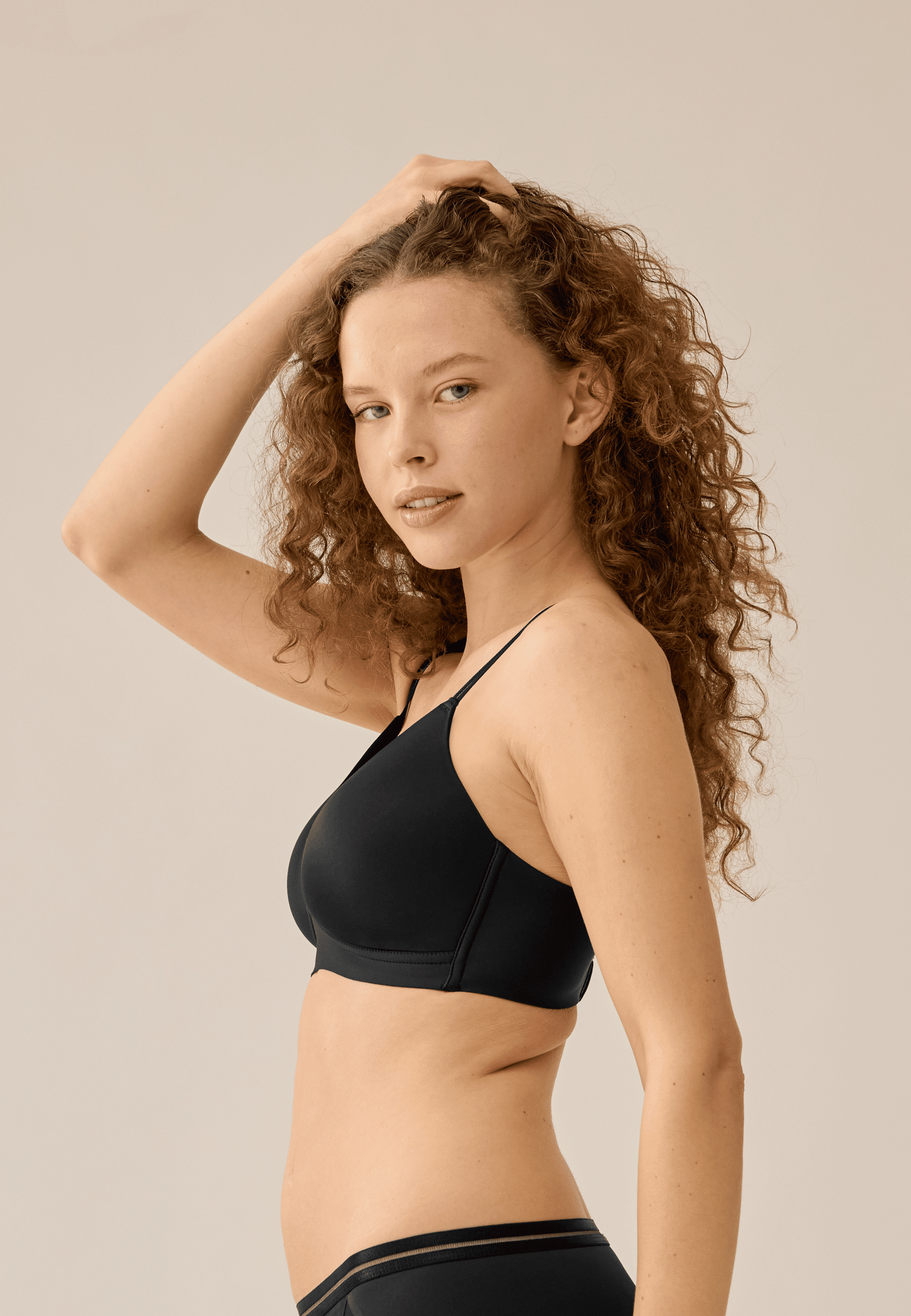 Zijde van vrouw die de voorgevormde soft bh met mesh detail in de kleur zwart van het merk Naturana draagt