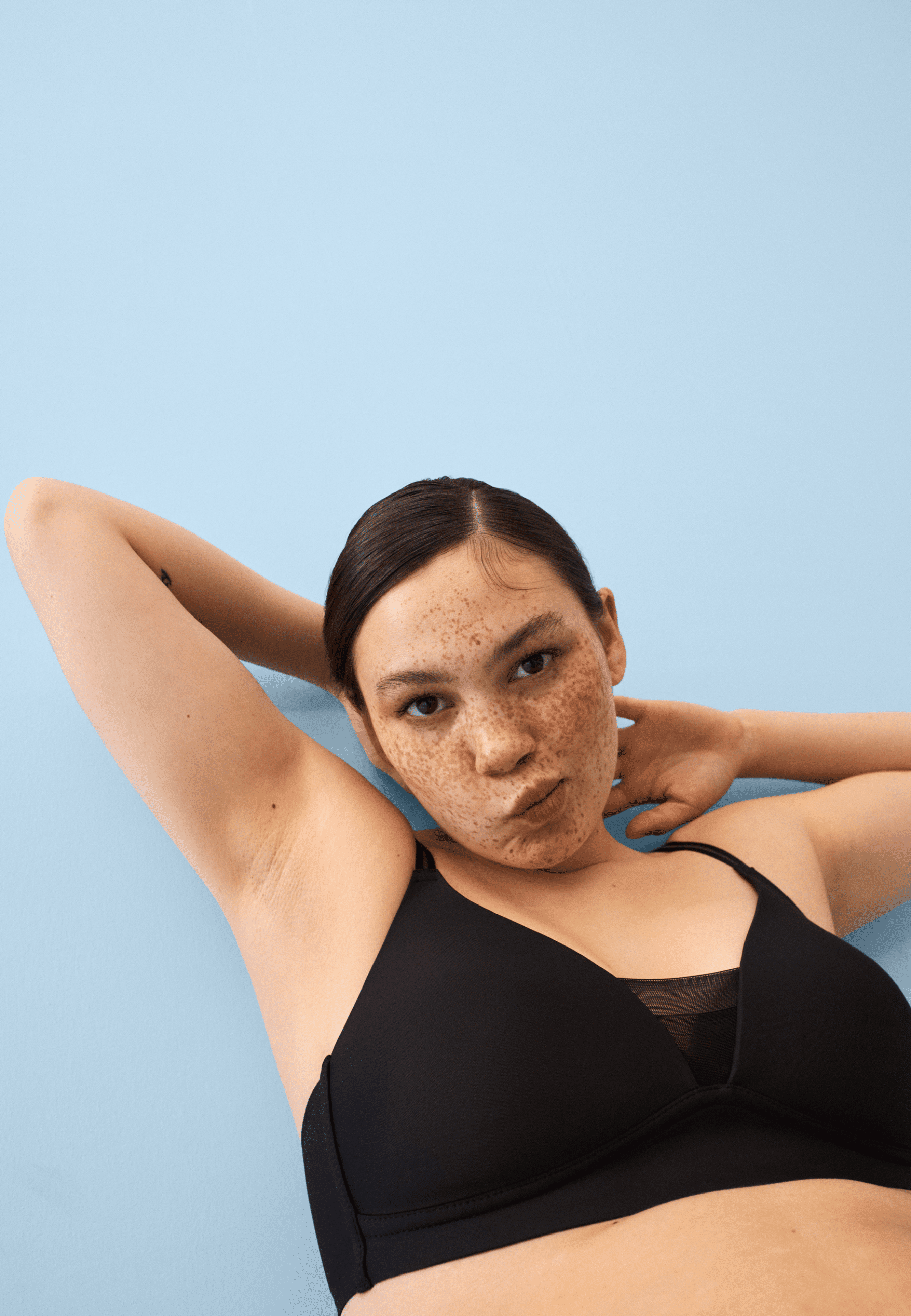 Voorzijde van vrouw die de voorgevormde soft bh met mesh detail in de kleur zwart van het merk Naturana draagt