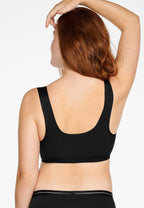 Achterzijde van vrouw die de soft bh met voorsluiting in de kleur zwart van het merk Natruana draagt